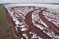 Plowed autumn field with first snow and tractor tracks Royalty Free Stock Photo