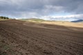 Plowed field, arable land, blue sky with clouds, landscape Royalty Free Stock Photo