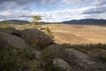 Plowed field, arable land, among the rocks, blue sky with clouds, landscape Royalty Free Stock Photo