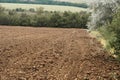 Plowed field and blue sky, soil and clouds of a bright sunny day - concept of agriculture Royalty Free Stock Photo