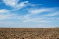 Plowed field and blue sky, soil and clouds of a bright sunny day - concept of agriculture Royalty Free Stock Photo