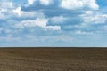 Plowed field fertile, black soil ready for sowing. Blue spring