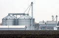 A plowed field in front of the grain-elevator complex