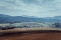 Plowed field after harvest of crops. Mountains on background.