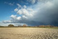 Plowed field, horizon and the coming dark cloud on the sky