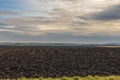 Plowed field ready for sowing. There are clouds over the landscape Royalty Free Stock Photo