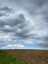 plowed field in spring and picturesque dark sky clouds before the storm in the spring Royalty Free Stock Photo