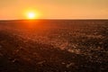 plowed field, textured arable land in the red light of the sunset Royalty Free Stock Photo