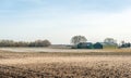 Plowed fields with a farm in the background Royalty Free Stock Photo