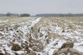 Plowed land in winter with deep furrows sprinkled with snow