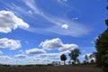 Plowed or Ploughed Field in Countryside and Blue Sky with Clouds over Horizon Royalty Free Stock Photo