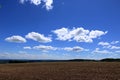 Plowed or Ploughed Field in Countryside and Blue Sky with Clouds over Horizon Royalty Free Stock Photo