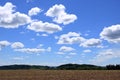 Plowed or Ploughed Field in Countryside and Blue Sky with Clouds over Horizon Royalty Free Stock Photo