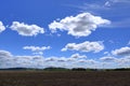 Plowed or Ploughed Field in Countryside and Blue Sky with Clouds over Horizon Royalty Free Stock Photo