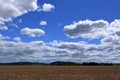 Plowed or Ploughed Field in Countryside and Blue Sky with Clouds over Horizon Royalty Free Stock Photo