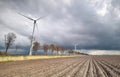 Plowed potato field and windmill turbines