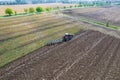 Plowing the ground with a tractor to which a plow is attached, aerial view. Agricultural production