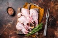 Plucked raw quails, fresh poultry on wooden board with spices. Dark background. Top view