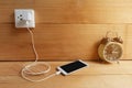 Plug in Adapter power cord charger of laptop computer On wooden floor Royalty Free Stock Photo