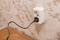 Plug in a double outlet on a white plaster background in a modern room interior Royalty Free Stock Photo