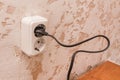 Plug in a double outlet on a white plaster background in a modern room interior Royalty Free Stock Photo