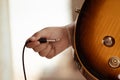 Plug jack cable in electric guitar,Hand inserts input jack to electric guitar Royalty Free Stock Photo