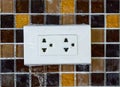 Plug socket on mosaic wall Royalty Free Stock Photo