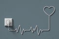 electric plug socket wire heart symbol rate shape white heartbeat or pulse monitor emergency lifesaving medical on wall grey. Royalty Free Stock Photo