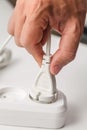 Plug in a white extension cord, male hand Royalty Free Stock Photo