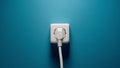 Plugged into an electrical outlet on a blue wall Royalty Free Stock Photo