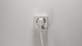 Plugged into an electrical outlet on a white wall Royalty Free Stock Photo
