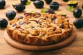 Plum biscuit cake on wooden background.