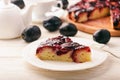 Plum bisquit cake on white wooden background. Royalty Free Stock Photo