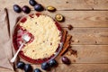 Plum crumble with aromatic spice on wooden rustic table top view. Autumn pastry.