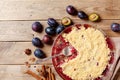 Plum crumble with aromatic spice on wooden rustic table top view. Autumn pastry dessert.