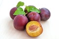 Plum with leaf isolated on wood background Royalty Free Stock Photo