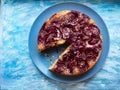 Plum pie on a blue plate on a blue background