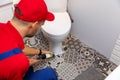 Plumber applying silicone sealant around water closet