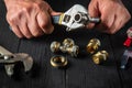Plumber connects brass fittings with an adjustable wrench. Close-up of hand of the master during work in workshop Royalty Free Stock Photo