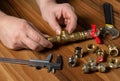 Plumber connects brass fittings while repairing equipment. Close-up of the hand of the master during work