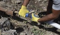 Plumber connects a water pipe in a trench