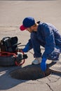 Plumber diagnoses a drain well on the street using special equipment Royalty Free Stock Photo