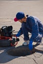 Plumber diagnoses a drain well on the street using special equipment