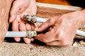 Compression ring is being positioned onto end of multilayer pipe by plumber preparing connection using metal fitting for Royalty Free Stock Photo