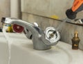 Plumber fixing faucet in bathroom Royalty Free Stock Photo