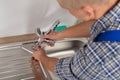 Plumber Fixing Faucet In Kitchen Sink Royalty Free Stock Photo