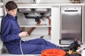 Plumber fixing the pipe sitting on the floor Royalty Free Stock Photo