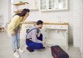 Plumber fixing the problem of a clogged sink pipe in the kitchen of a young woman& x27;s house