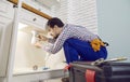 Plumber fixing some problems with the kitchen sink, repairing pipes or unclogging the blockage Royalty Free Stock Photo