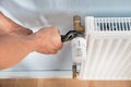 Plumber fixing radiator with wrench Royalty Free Stock Photo